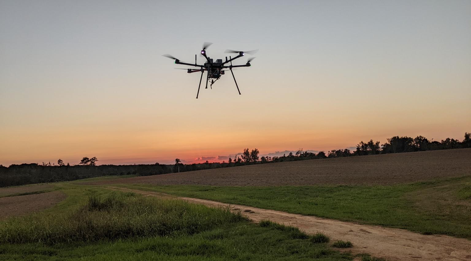AERPAW UAV in flight at sunset over the Lake Wheeler Field Labs
